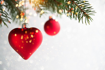 Wall Mural - red christmas ornaments, heart and ball, on the xmas tree on glitter bokeh background with twinkle l