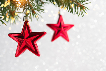 Wall Mural - red christmas ornaments, stars, on the xmas tree on glitter bokeh background with twinkle lights. me