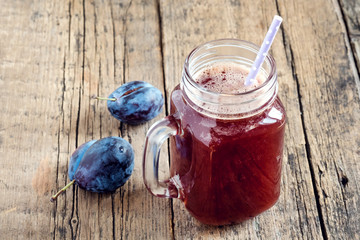 Appetizer fresh plum juice in glass jar on wooden background Fresh plum smoothie Copy space Above