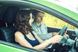 © Artem - Driving instructor teaching driving in the car the woman beginner. Lesson in driving school.