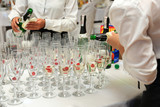 Fototapeta  - Kelnerki wlewają szampana do kieliszków na przyjęciu weselnym.