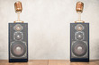 Retro stereo acoustic speakers system and golden microphones front concrete wall background. Listening music concept. Vintage old style filtered photo