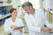 © auremar - woman pointing at laptop screen when talking to pharmacist