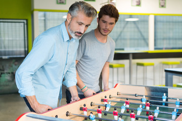 businesspeople playing table soccer game during their free time