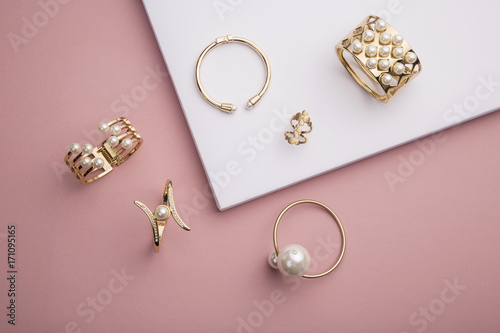 Cuadros en Lienzo Pearl Golden Bracelets and ring on pink and white background