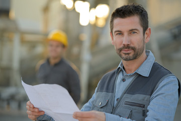 happy engineer in against construction site