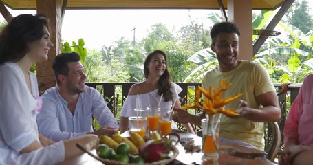 Wall Mural - happy people group on summer terrace talking, diverse friends together sitting at table drinking jui