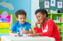 Two Boy Kid Sit On Table And Reading Tale Book  In Preschool Library,Kindergarten School Education Concept