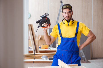 Young repairman carpenter working cutting wood on circular saw