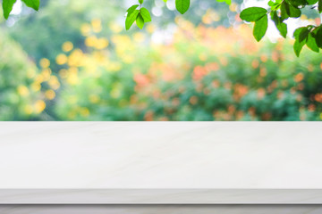 Wall Mural - Empty white marble table over blur green park background, product display montage