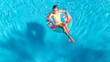 © Iuliia Sokolovska - Aerial view of girl in swimming pool from above, kid swim on inflatable ring donut and has fun in water on family vacation