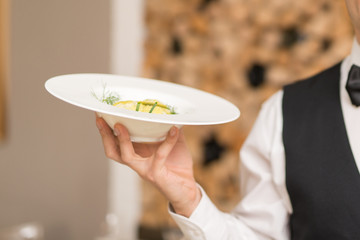 Waiter holding a dish in a restaurant