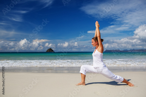 Fotografia Caucasian woman practicing yoga at seashore of tropic ocean