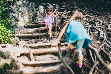children - twin girls are hiking in the mountains.