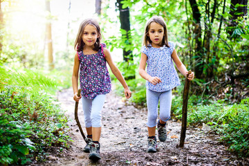 children - twin girls are hiking in the mountains.