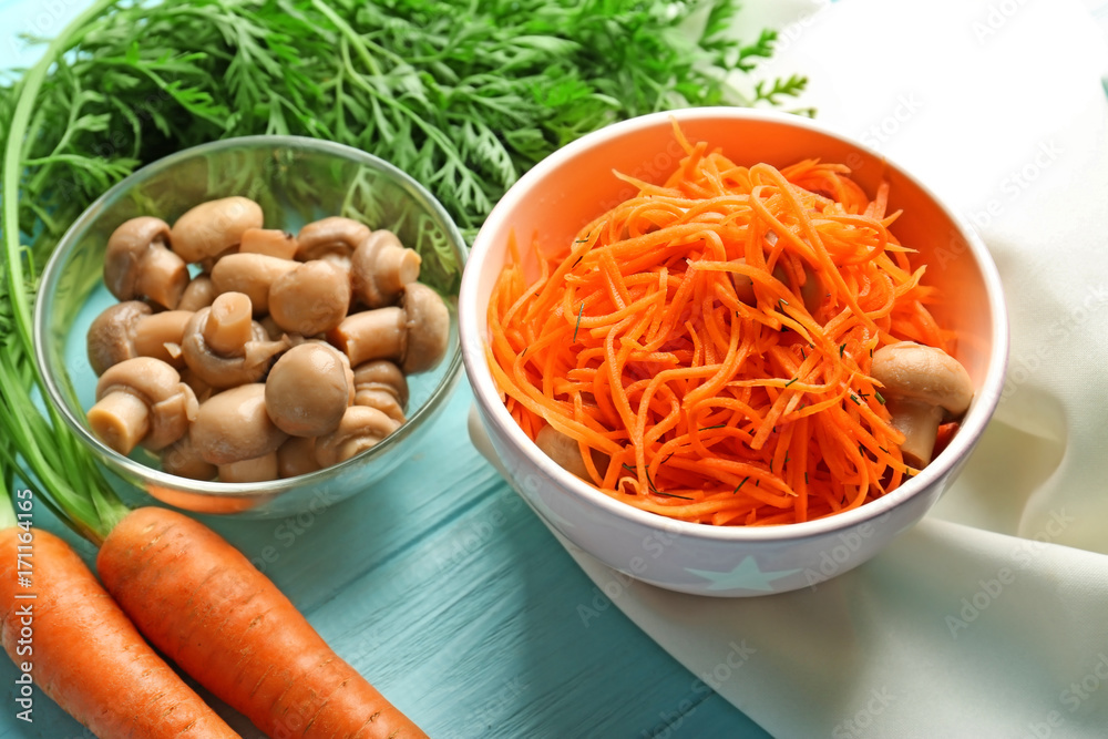 Bowl with delicious carrot salad on wooden table