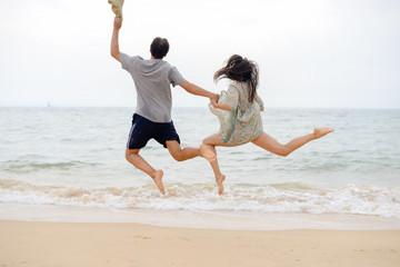 Lovely couple having fun on the beach outdoors background. Back view of healthy people, excitement and amazement emotional freedom leisure. Travel vacation attractive enjoyment lifestyle.