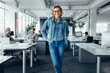 © Jacob Lund - Cheerful businesswoman standing in office environment