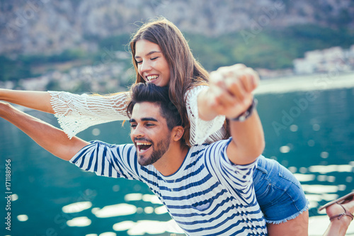 Young beautiful tourist couple enjoying summer holiday on the seaside Poster