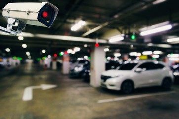 CCTV, security indoor camera system operating with blurred image of under ground indoor car parking garage area, RFID solution management system, surveillance security and safety technology concept