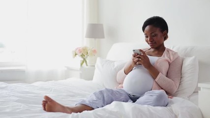 Wall Mural - happy pregnant woman with smartphone at home