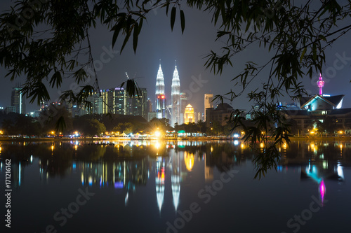 Obraz na plátne Night view of Kuala Lumpur skyline framed by bamboo tree leaves as seen from Taman Tasik Titiwangsa also known as Titiwangsa Lake Garden located in Kuala Lumpur, Malaysia