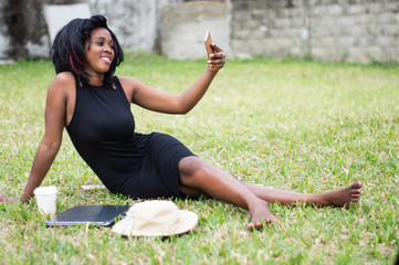 African woman doing a selfie in a park