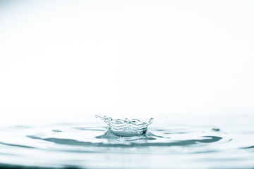 Wall Mural - water drop and splash on water surface on blue background