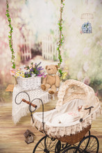 Vintage Baby Carriage On A Rope Swing Background With A Basket Of Flowers And A Teddy Bear. Studio Photography.
