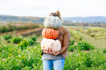 beautiful woman with three huge pumpkins on farm