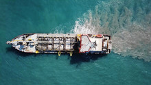 Suction Dredger Ship Working Near The Port - With Mud, Pollution, Brown Muddy Water - Aerial Tip Down Shot