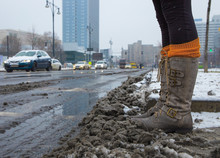 A Woman Running Through Dirty Snow Mat In A City