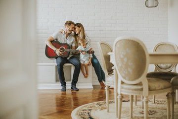 Wall Mural - Lovely young couple with guitar in the room