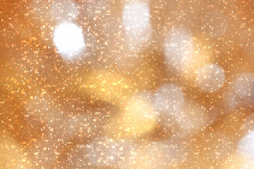 Golden abstract sparkles or glitter lights. Festive gold background.defocused circles bokeh or particles. Valentines day template