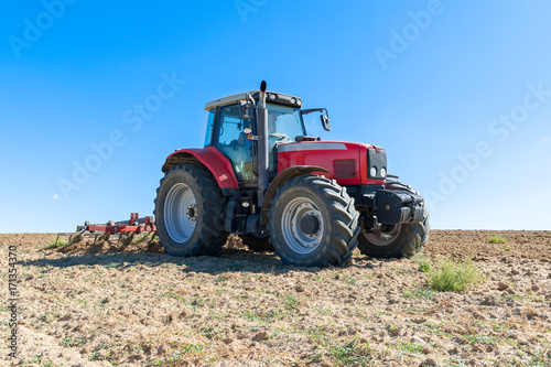 agricultural tractor in the foreground with blue sky background. Obraz na płótnie