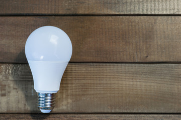 Leinwandbilder - Led lamp green technologies background. Wooden table, eco lamp. Energy efficiency concept.