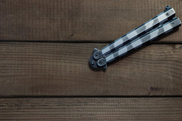 Aufkleber - Steel butterfly knife  on a wooden background