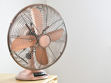 Rose Gold Colored Traditional Electric Fan In A Home.