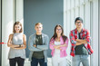 © F8  \ Suport Ukraine - Four friends standing with crossed hands and smiling indoors. Fours students in university.