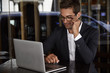 © sanneberg - Business guy working on laptop at table