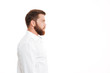 © Drobot Dean - Serious young bearded man standing over white wall