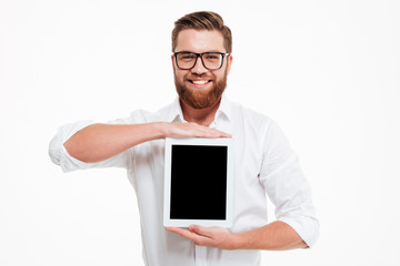 Cheerful young bearded man showing display of tablet computer.
