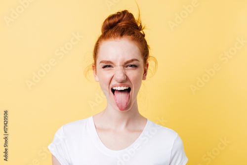 Fotografía Funny ginger woman showing tongue and looking at the camera