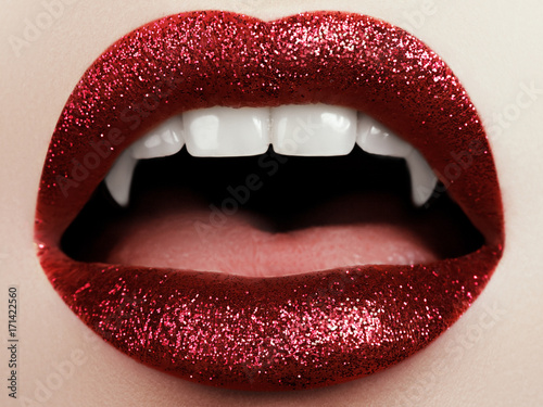 Fotomural Female lips with glittering red lipstick, vampire teeth