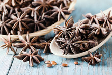 Whole Star Anise In A Basket And Spoon On Wooden Background