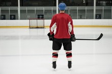 Rear View Of Hockey Player At Ice Rink