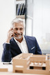 © Westend61 - Mature businessman examining architectural model in office