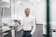 © Westend61 - Mature businessman holding cell phone in office