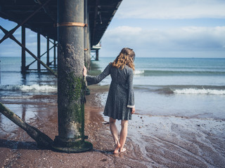 Young woman standing under pier