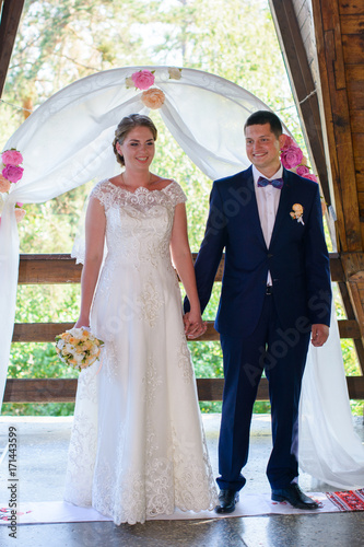 Young Bride And Groom At The Wedding Ceremony Under The Arch A